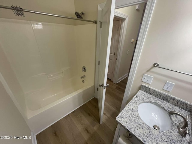 bathroom with vanity, wood finished floors, and shower / tub combination