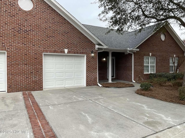 ranch-style house with a shingled roof, concrete driveway, brick siding, and an attached garage