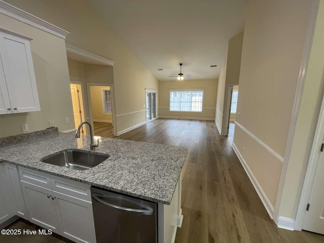 kitchen featuring dishwasher, light stone counters, open floor plan, a peninsula, and a sink