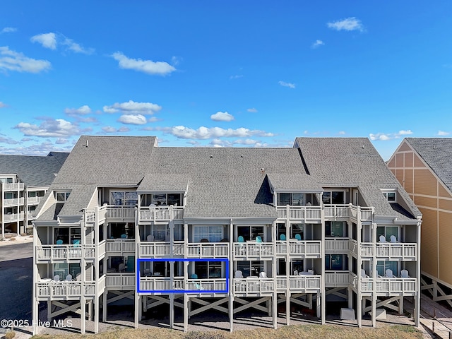 rear view of house featuring a shingled roof