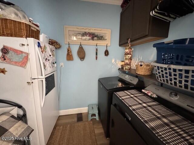 kitchen featuring washing machine and dryer, baseboards, and freestanding refrigerator