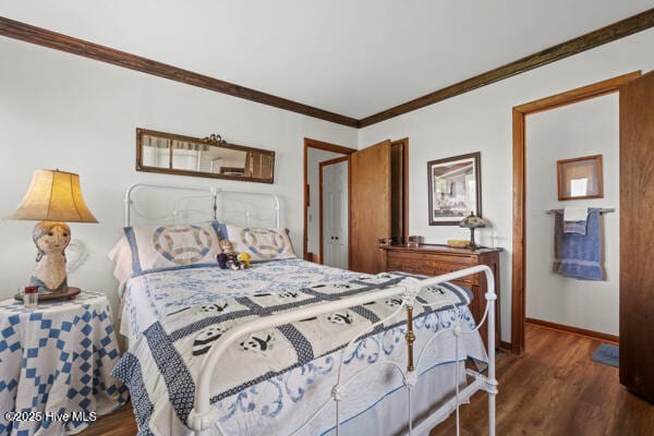 bedroom with baseboards, ornamental molding, and wood finished floors