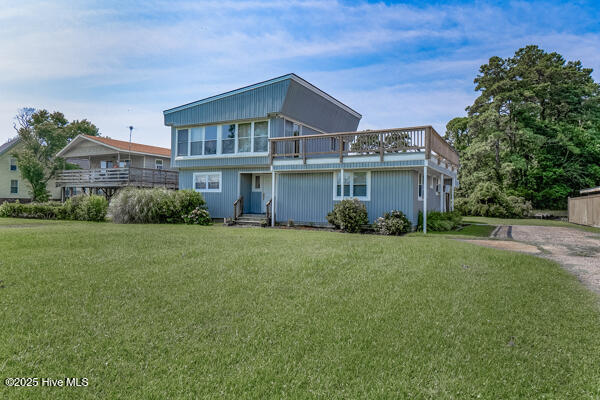 view of front of house with entry steps, driveway, and a front lawn