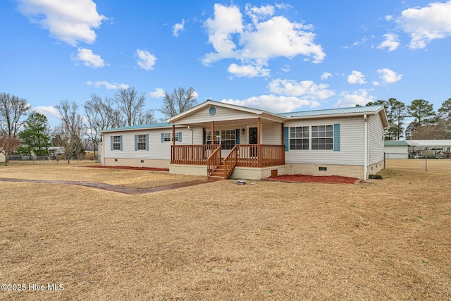 view of front of home featuring covered porch, a front yard, crawl space, metal roof, and fence