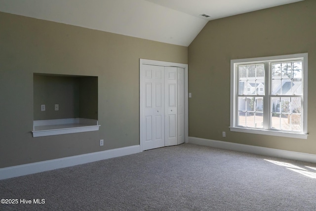 unfurnished bedroom featuring vaulted ceiling, carpet, visible vents, and baseboards