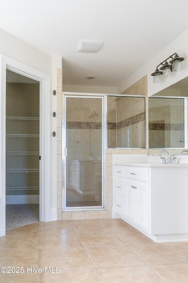 bathroom with a shower stall, vanity, and tile patterned floors