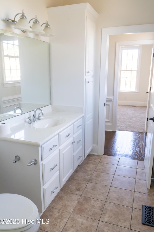 bathroom featuring visible vents, toilet, vanity, and tile patterned floors