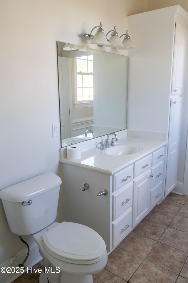 half bathroom featuring vanity, toilet, and tile patterned floors