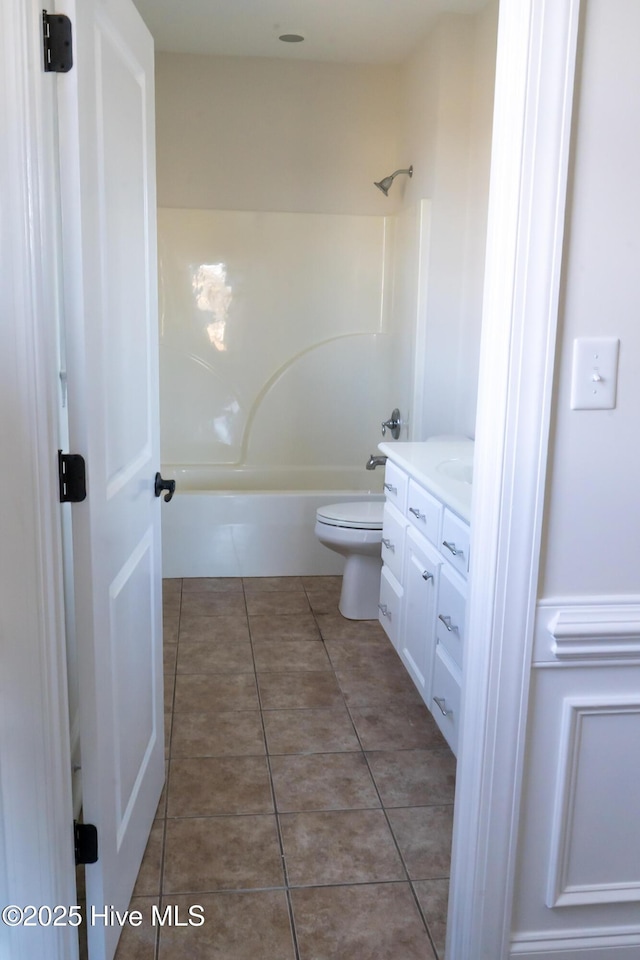 bathroom featuring bathtub / shower combination, vanity, toilet, and tile patterned floors