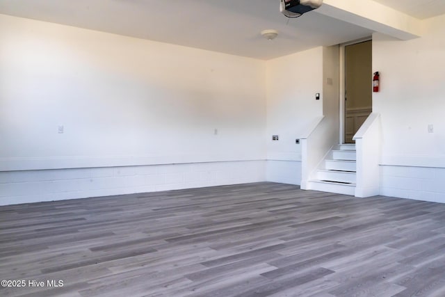 spare room with stairs and wood finished floors