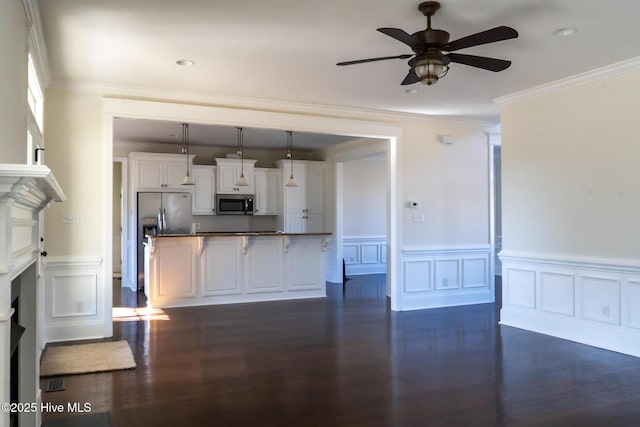 kitchen featuring dark wood-style flooring, pendant lighting, dark countertops, appliances with stainless steel finishes, and white cabinets