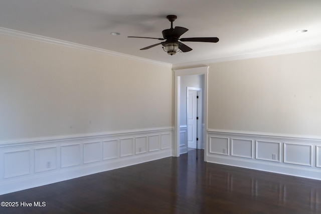 unfurnished room with dark wood-style floors, ceiling fan, crown molding, and wainscoting