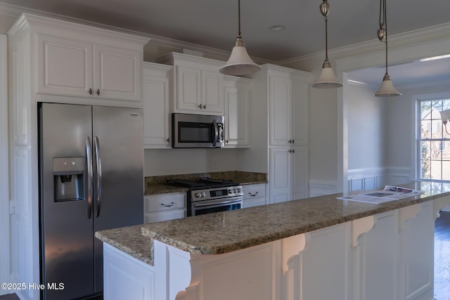 kitchen with a kitchen breakfast bar, appliances with stainless steel finishes, white cabinetry, and crown molding