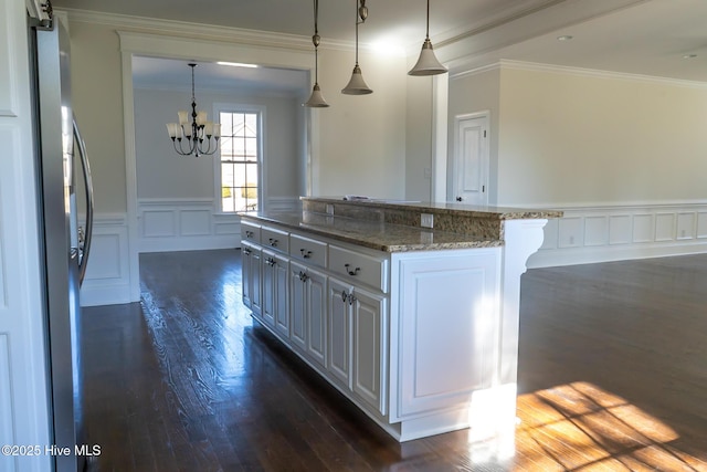 kitchen featuring ornamental molding, dark wood-style flooring, wainscoting, and light stone counters