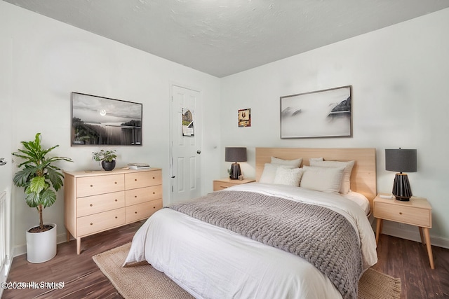 bedroom featuring dark wood finished floors and baseboards