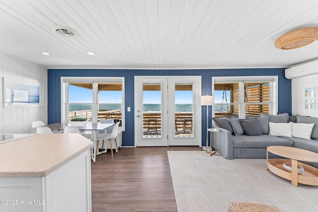 living room with an AC wall unit, visible vents, wooden ceiling, and wood finished floors