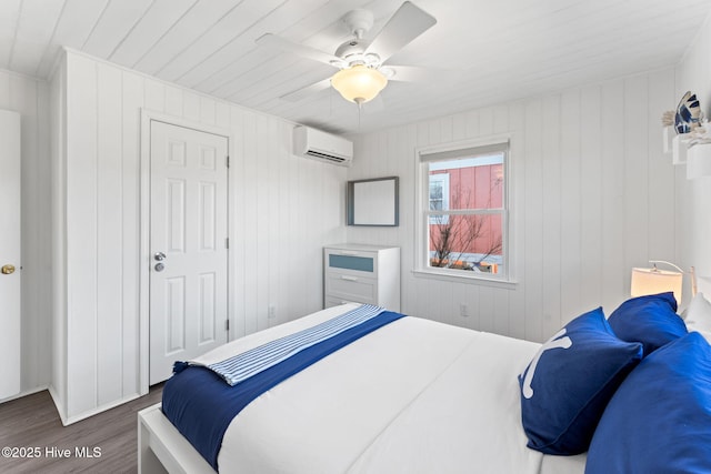 bedroom with ceiling fan, dark wood finished floors, and an AC wall unit