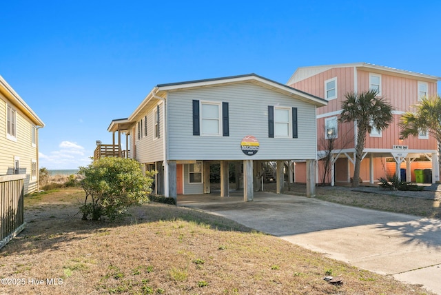 raised beach house featuring driveway and a carport