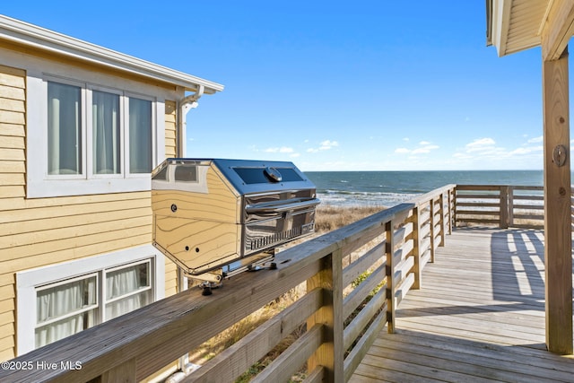 exterior space with a view of the beach, a water view, and a grill