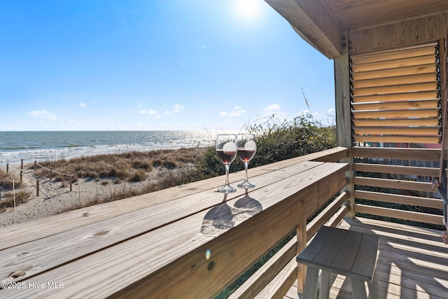 wooden deck with a view of the beach and a water view