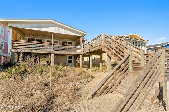 rear view of property featuring a deck and stairway