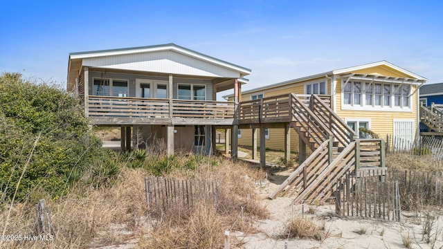 rear view of house featuring stairs and a deck