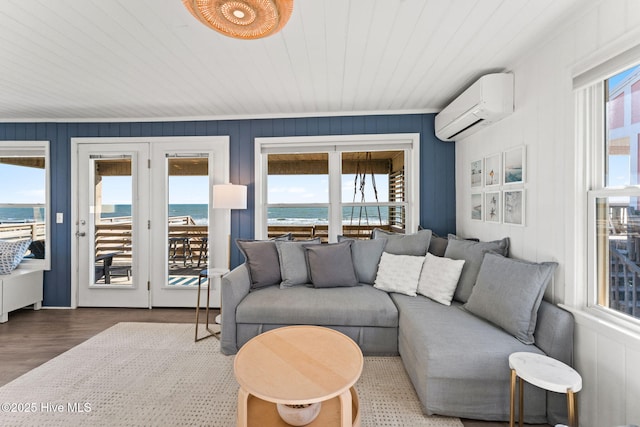 living room featuring an AC wall unit, a water view, wood finished floors, and wooden ceiling