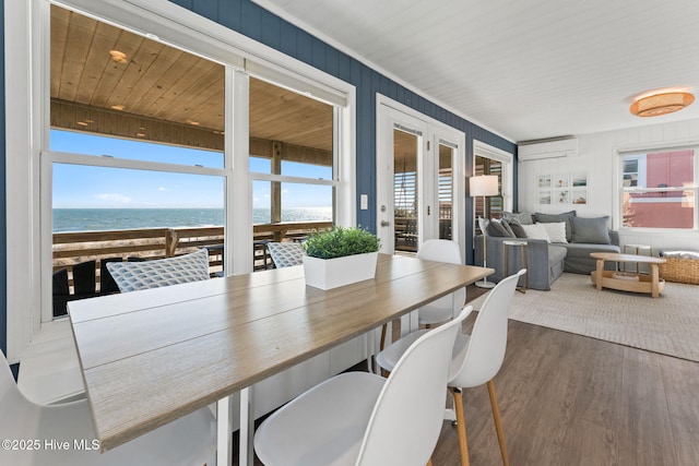 sunroom / solarium with an AC wall unit and a water view