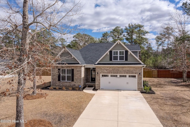 craftsman-style home featuring driveway, roof with shingles, fence, and brick siding