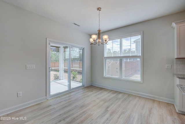 unfurnished dining area featuring light wood finished floors, baseboards, and visible vents