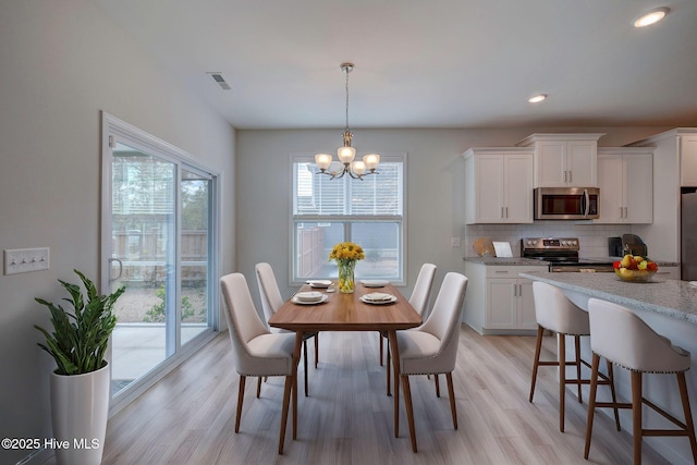 dining space featuring light wood finished floors, visible vents, a chandelier, and recessed lighting