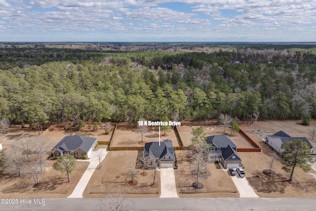 bird's eye view with a wooded view