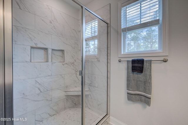 bathroom with a shower stall and baseboards