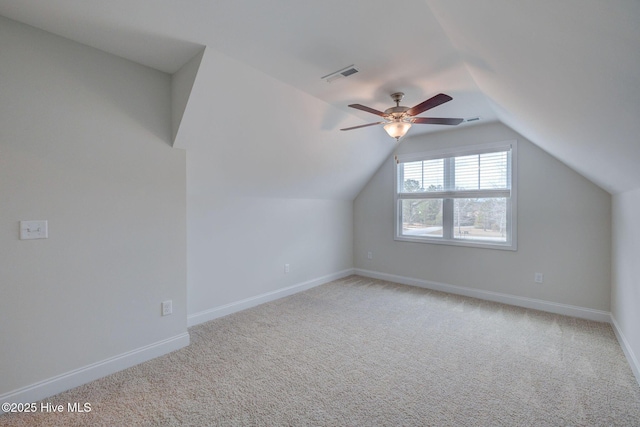 additional living space with light carpet, vaulted ceiling, visible vents, and baseboards