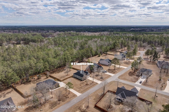 bird's eye view with a wooded view