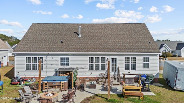 back of house with a yard, a shingled roof, an outdoor fire pit, entry steps, and a patio area