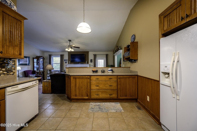 kitchen with white appliances, a wainscoted wall, brown cabinets, a peninsula, and open floor plan