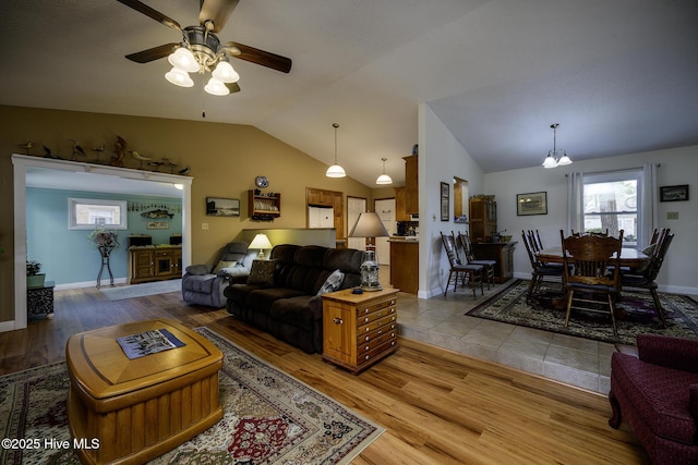 living room featuring ceiling fan, baseboards, lofted ceiling, and wood finished floors