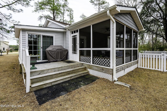 view of side of property with fence and a sunroom