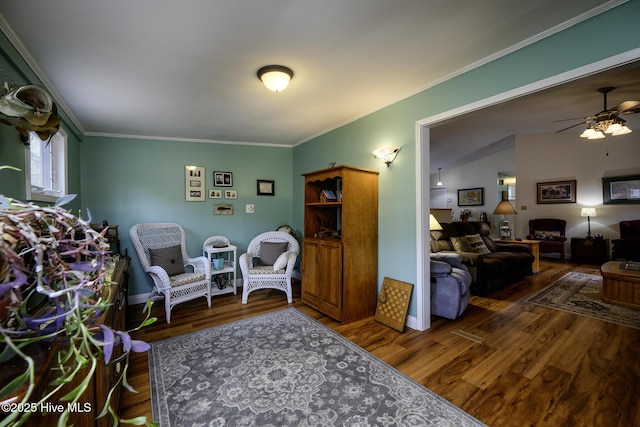 living area featuring ceiling fan, wood finished floors, and ornamental molding