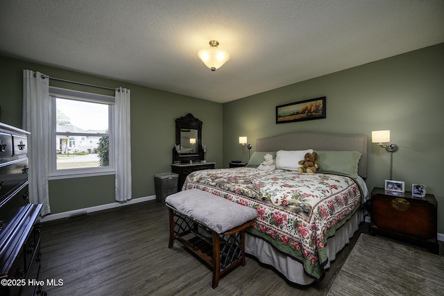 bedroom with baseboards, a textured ceiling, and wood finished floors