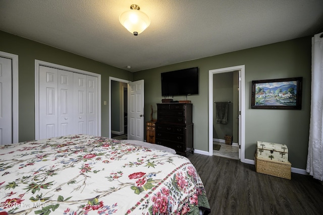 bedroom with dark wood-style floors, baseboards, multiple closets, ensuite bathroom, and a textured ceiling