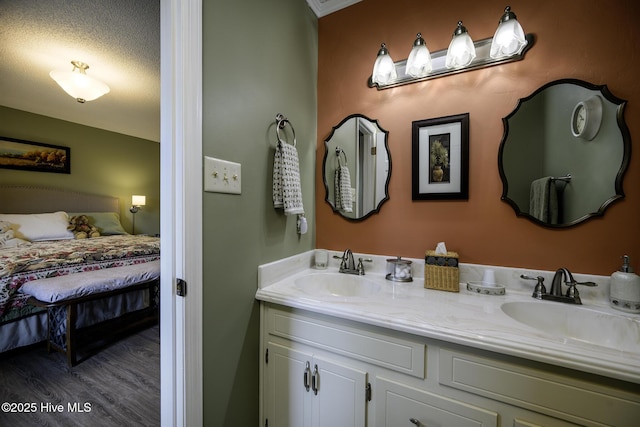 bathroom featuring a sink, double vanity, wood finished floors, and ensuite bathroom