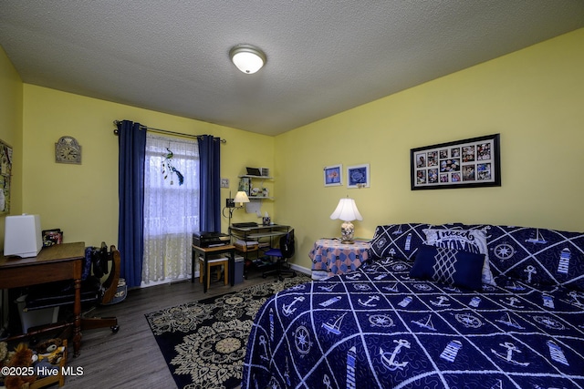 bedroom with baseboards, a textured ceiling, and wood finished floors