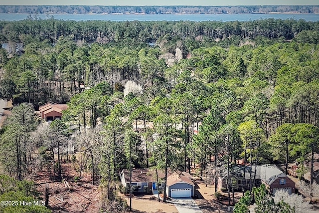 birds eye view of property featuring a forest view and a water view