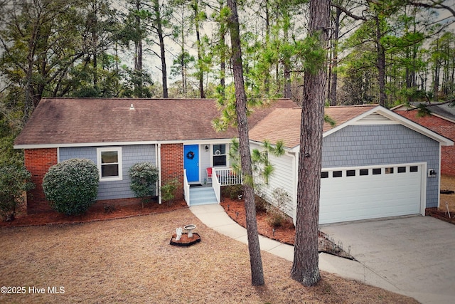 ranch-style house featuring a garage, concrete driveway, and a shingled roof