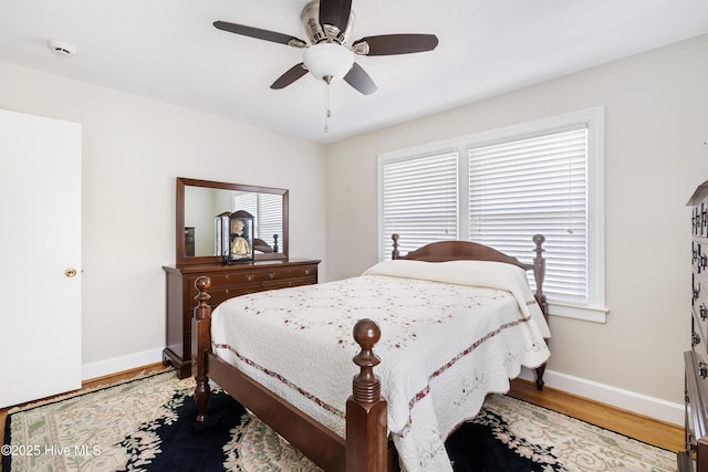 bedroom featuring ceiling fan, baseboards, and wood finished floors