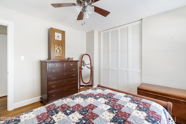 bedroom featuring ceiling fan, baseboards, a closet, and wood finished floors