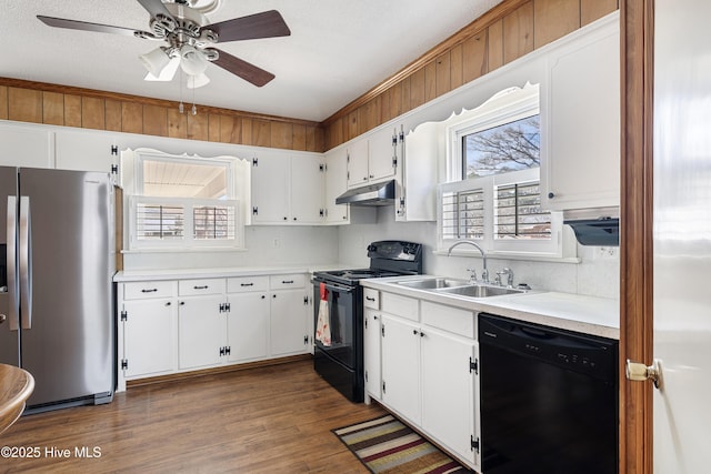 kitchen with black appliances, plenty of natural light, under cabinet range hood, and a sink