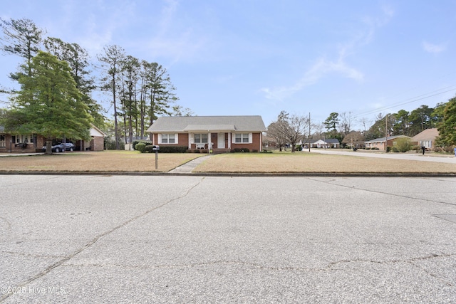 view of front of house with a front yard and brick siding